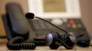 Telefon davostiers e headset davant. 