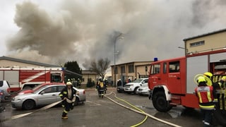 Pumpiers entuorn la staziun da gas. Davostier ves'ins ina nebla da fim