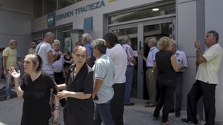 persunas pensiunadas spetgan avant las portas d'ina banca en Grezia