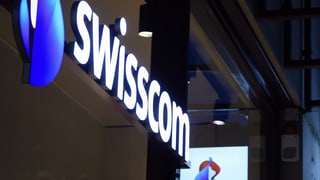 Logo da Swisscom illuminà vi d'ina chasa.