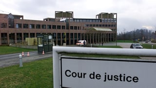 bajetg da dertgira, davant ina tavla cun l'inscripziun "cour de justice"