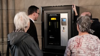 Glieud enturn l'automat d'unfrir en la Baselgia averta Elisabeth a Basilea.
