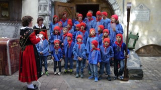 20 uffants da Guarda han festivà Chalandamarz en l'Europa-Park - els stattan davant la chasa dal Uorsin da la stgella a Rust