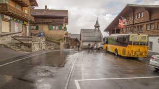 Entamez il vitg d'Andiast, la scola cun il plaz dils autos da posta.