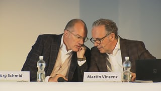 Jürg Schmid e Martin Vincenz sesan davos ina maisa e discurran