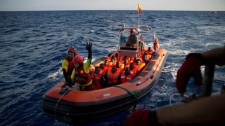 Fugitivs en ina bartga da salvament sin la mar mediterrana.