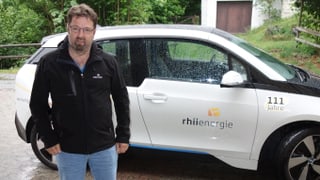 Venanzi Pfister da la Rhiienergie davant in auto electric.