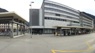 L'edifizi grisch da l'anteriur Globus a la staziun da Cuira, davant ves'ins la staziun da bus.