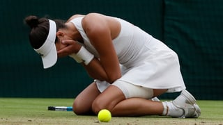 Giugadra da tennis cun mauns davant la fatscha.