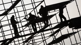 Purtret da lavurers sin in palancà da construcziun. 