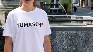 Ina giuvna cun il t-shirt da Tumasch avant la funtauna sper la plazza dal teater a Cuira. Ins na vesa betg la fatscha da la giuvna. Ina giuvna cun il t-shirt da Tumasch avant la funtauna sper la plazza dal teater a Cuira. Ins na vesa betg la fatscha da la giuvna.