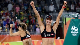 duas dunnas che sa legran da lur victoria en il beachvolleyball
