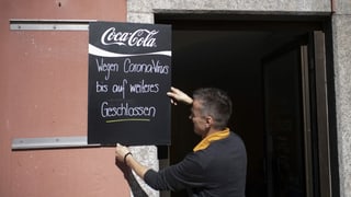 Persuna penda si tavla cun si "Wegen Coronavirus bis auf weiteres geschlossen"