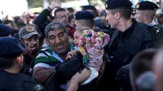 Polizia corata fraina ils migrants al cunfin.