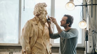 L'artist Inigo Gheyselinck lavura vid la statua da l'artist Segantini.