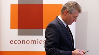 Heinz Karrer, il president d'Economiesuisse guarda sin ses telefonin.