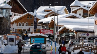 Il vitg da Samignun. Bleras chasas cun naiv sin ils tetgs e turists sin via.