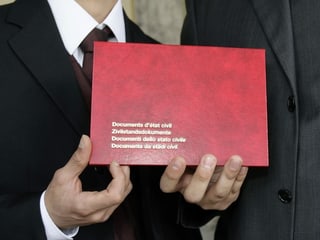Pèrin mussa la cuverta cun ils documents dal stadi civil.