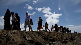Fugitivs dals Rohingya che chaminan in suenter l'auter.