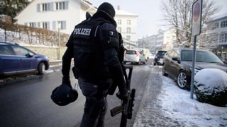 Policist cun arma.