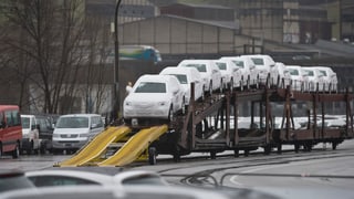 Autos novs protegids cun ina cuverta sin in char da tren.