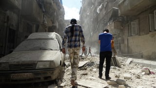 Dus umens avant ina auto destruì ad Aleppo en Siria. 