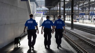 Trais guardia cunfin da la Svizra a Basilea sin la staziun. 