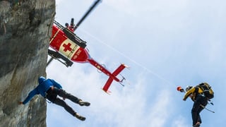 In herlicopter da salvament cun duas persunas. Exercizi da salvament vi d'in grip. 