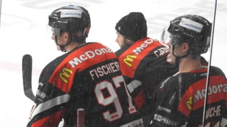 Trais giugaders da hockey a la banda