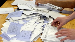 Dus mauns che sorteschan scrits da votaziuns ed elecziuns.