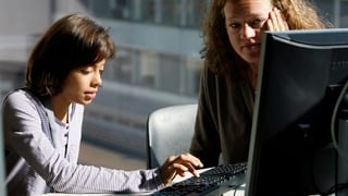 Purtret d'ina giuvna davant in computer. Ina dunna survegilescha quai. 