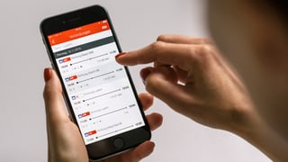 Ina dunna cumpra in bigliet via telefonin.