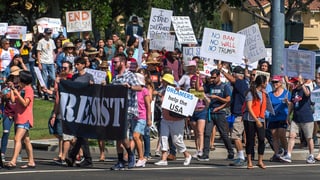 pliras persunas protesteschan cun placats