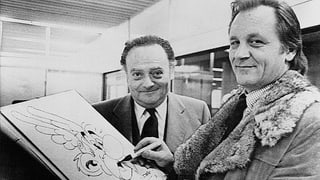 Autur René Goscinny (a sanestra) cun dissegnadur Albert Uderzo. Autur René Goscinny (a sanestra) cun dissegnadur Albert Uderzo.
