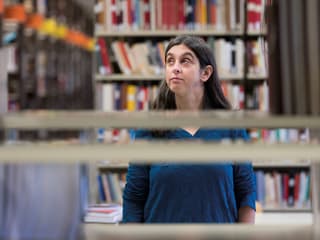 La istorichera Christina Späti en la biblioteca da l'universitad Friburg.