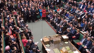 La sala dal parlament cun parlamentaris e Theresa May che tegna in pled. 