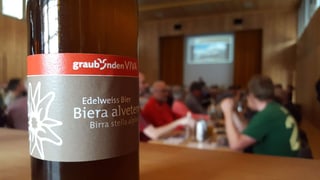 A sinistra ina buttiglia bira, a dretga ils acziunaris a la radunanza