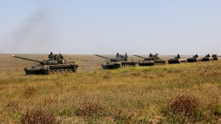 Tancs in viadi atras ina savanna.