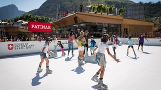 Visitaders sin la patinera sintetica en il «House of Switzerland».