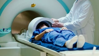 Pazient che vegn manà en in MRI.