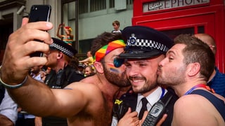 Dus visitaders dattan in bitsch ad in policist che procura per la segirtad a la Gay Pride. 
