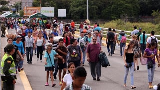 Persunas che traversan cun cumpras ina punt.