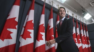 Il nov primminister dal Canada avant bandieras dal Canada.