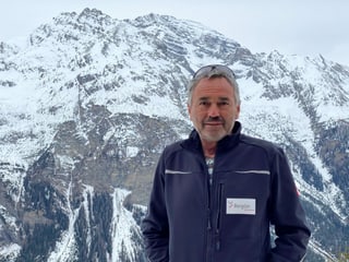 Il patrugliader Linard Gregori a Darlux cun vista vers il Piz Ela.
