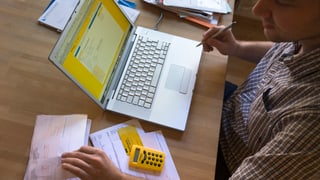 Purtret d'in um che paja en quints sur e-banking. 