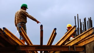 Dus lavurers stattan sin ina construcziun da metal.