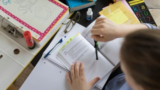 In maun d'uffant e bler material da scola per la preparaziun da l'examan d'admissiun.