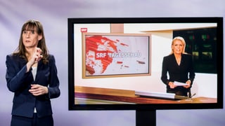 Tagesschau cun dunna che mussa la lingua da segns. 
