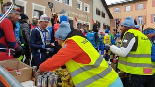 Stan da mangiar e baiver en l'arriv, davos maisa dus voluntaris cun gilets mellans, sin maisa bananas e Red Bulls, da l'autra vart ils curridurs che prendan tge ch'han gust.