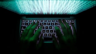 Purtret d'in computer e mauns che scrivan.